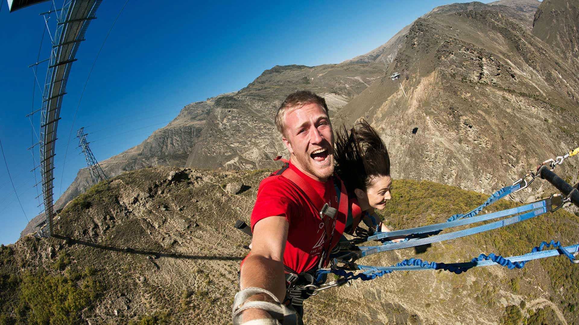 Two people jumping off the Nevis Swing