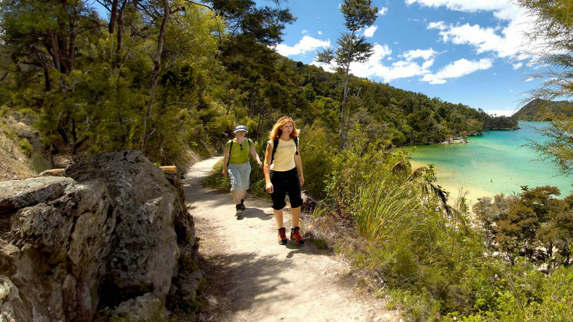 Two people walking in Abel Tasman National Park