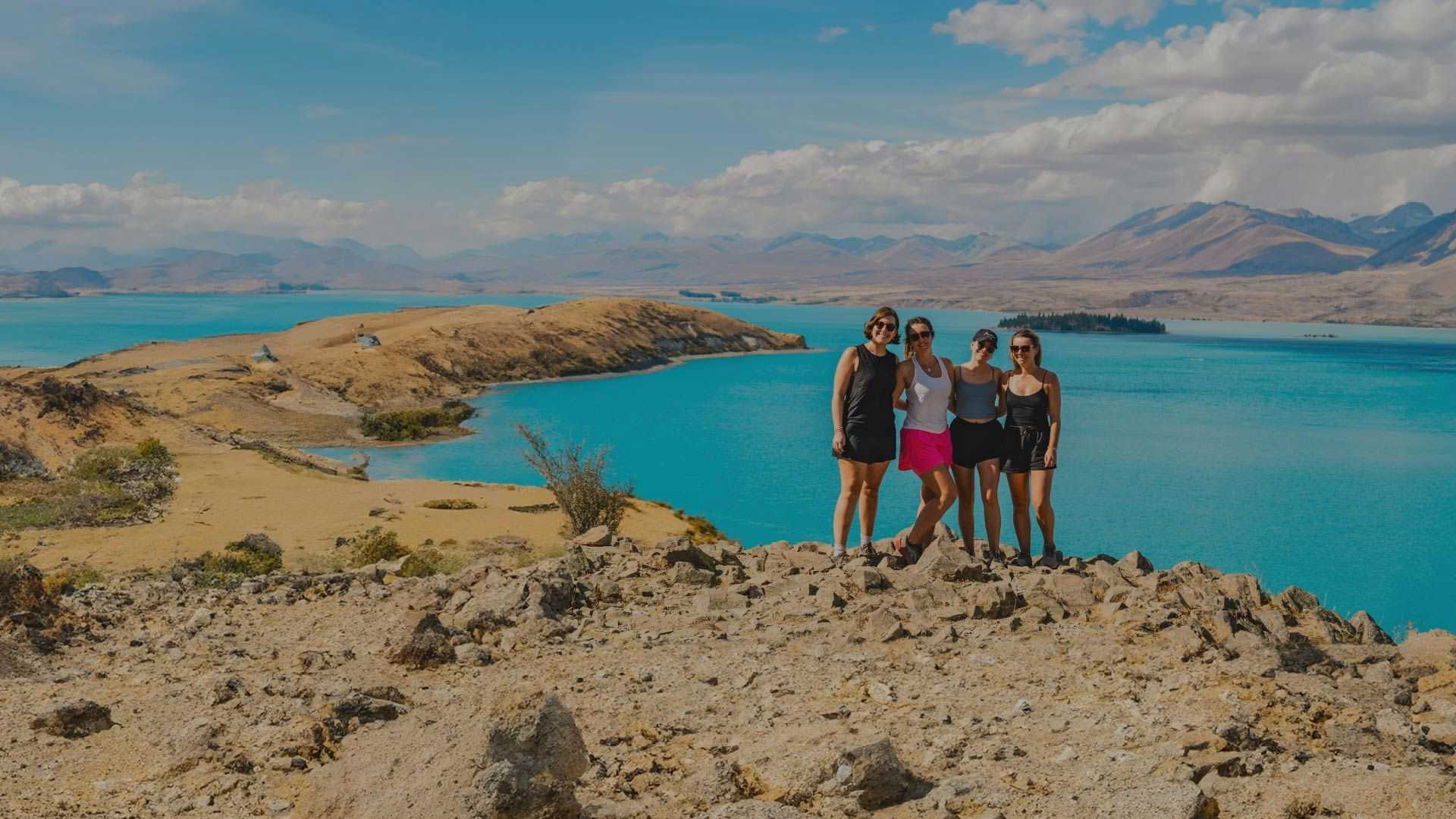Group of women posing for a photo overlooking Lake Tekapo in New Zealand