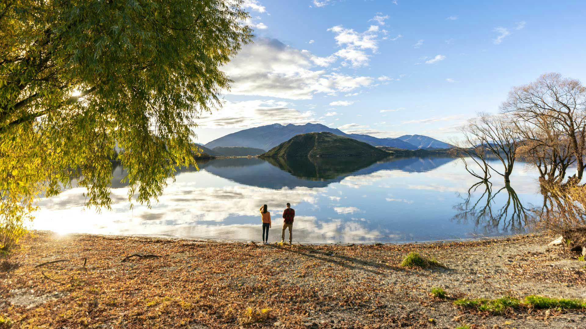 Two people standing on the shores of Lake Wanaka iin New Zealand