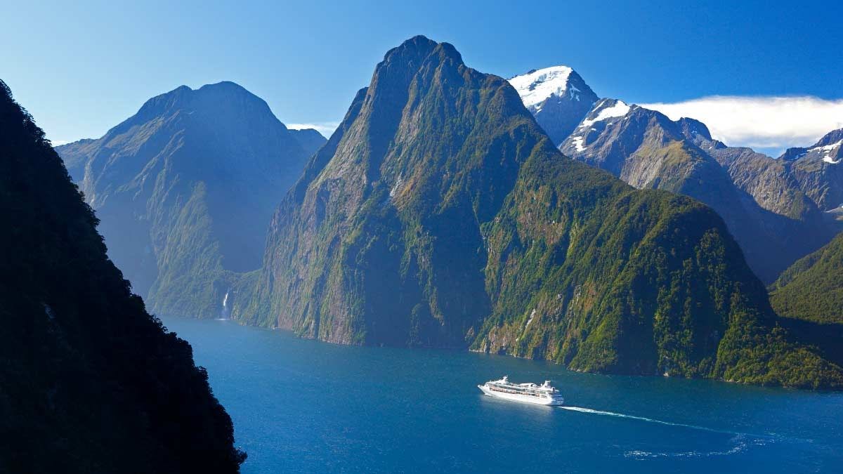 Boat cruises through Milford Sound in New Zealand