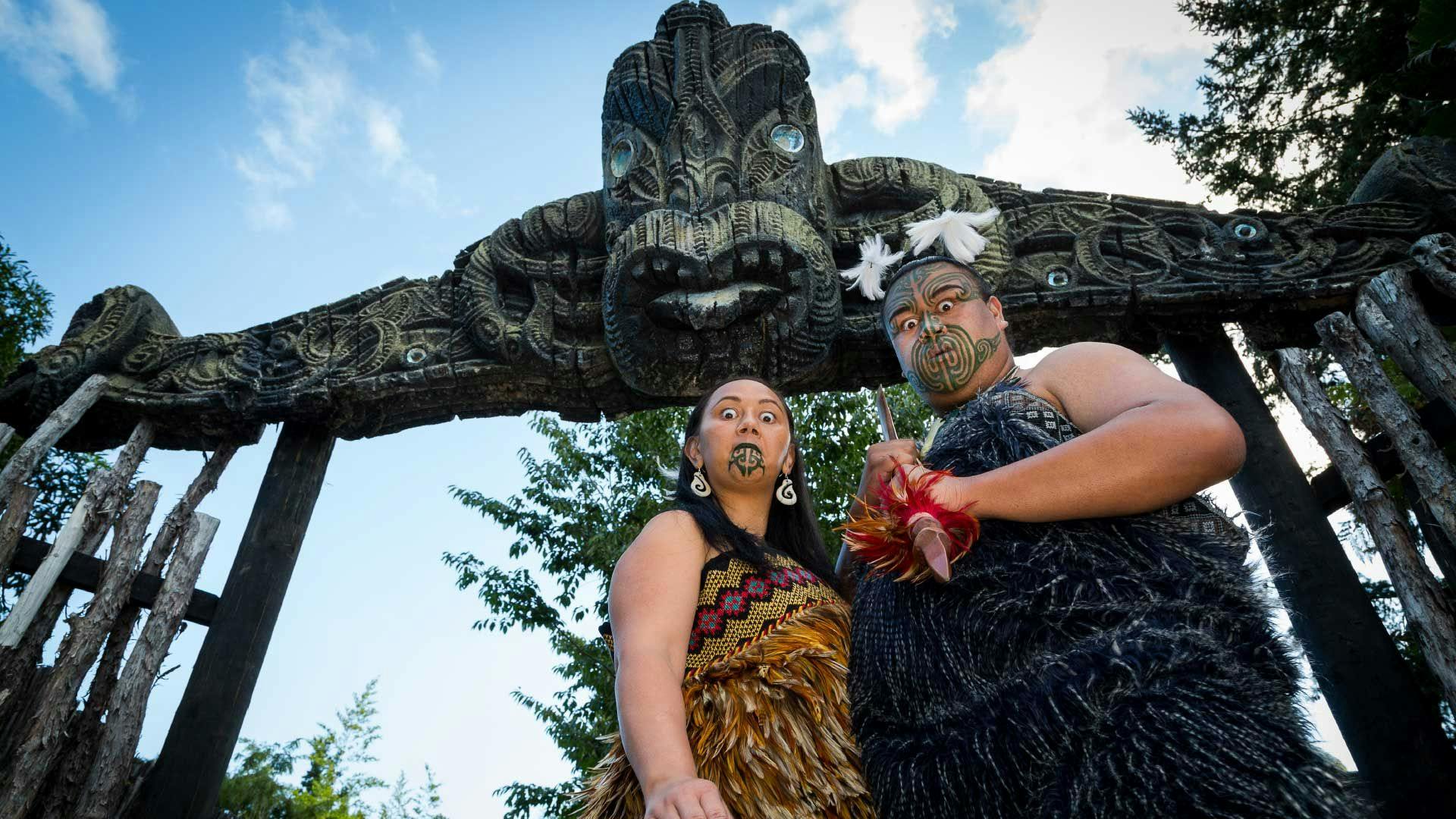 Māori man and woman greet visitors at Mitai Maori Village in Rotorua