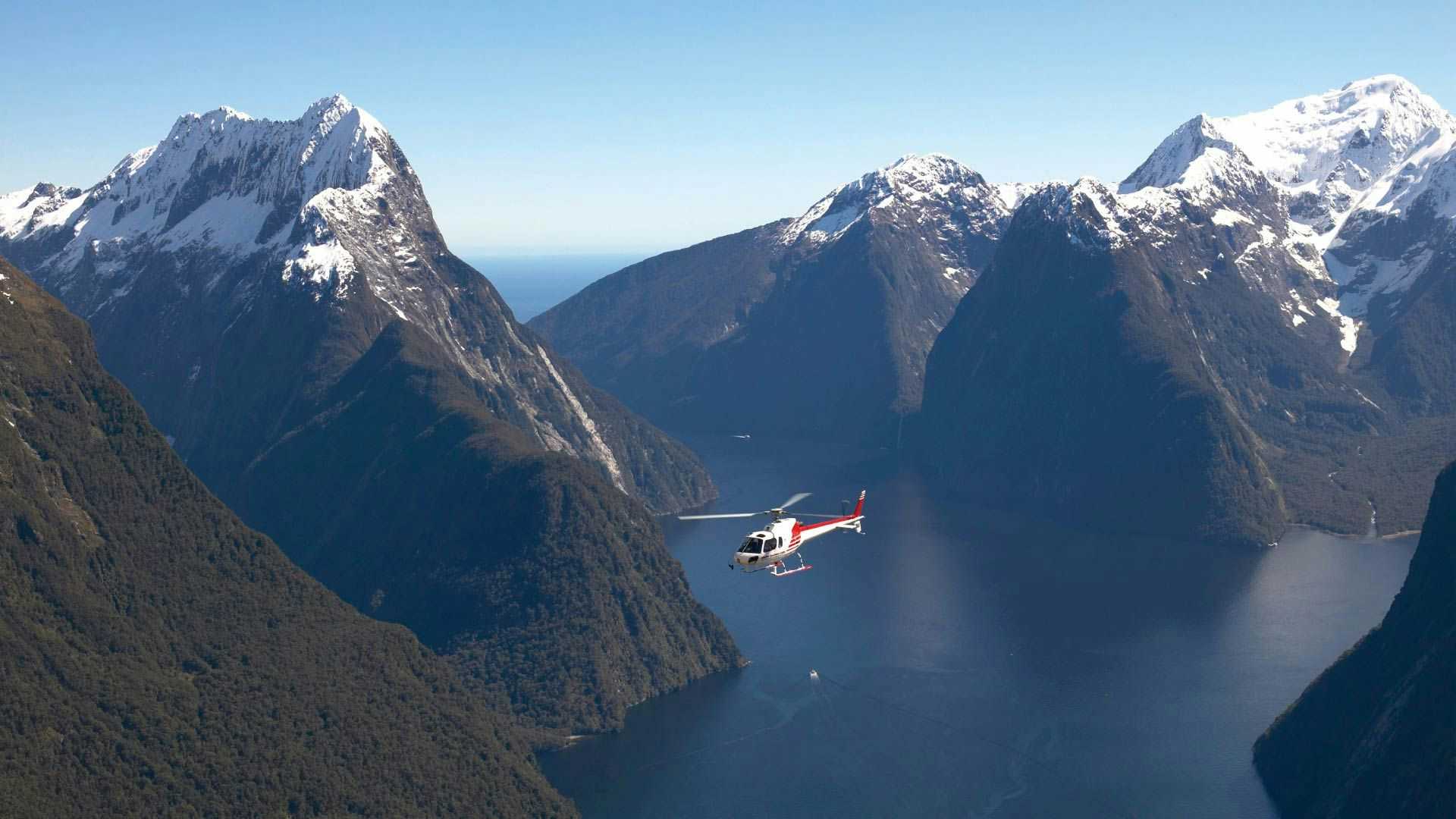Helicopter flying through Milford Sound in New Zealand