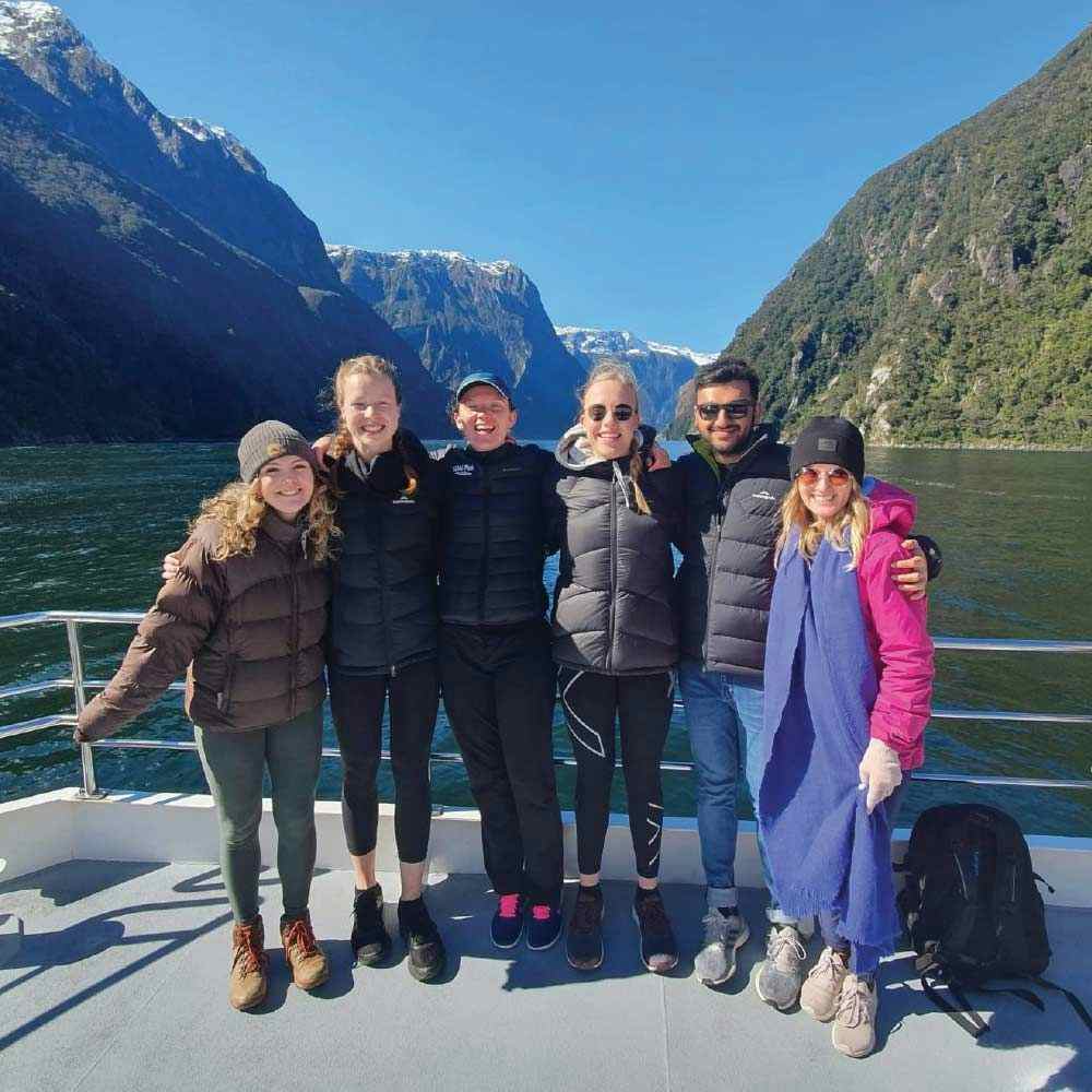 Group of friends on a boat cruise in Milford Sound in New Zealand